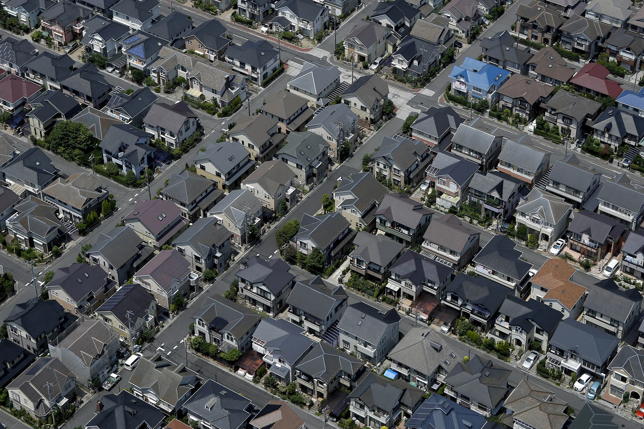 Residential buildings stand in this aerial photograph taken in Urayasu, Chiba Prefecture, Japan, on Wednesday, June 24, 2015. The Abe administration aims to cap increases in spending as it tries to rein in the world's heaviest debt load while sustaining a recovery from two decades of stagnation.
