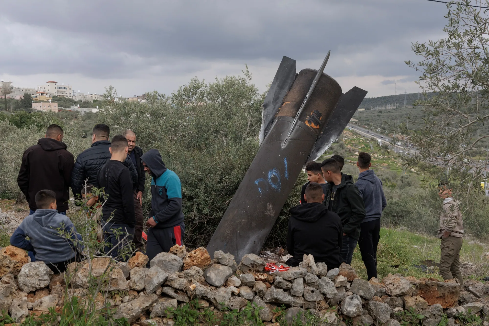 Palestinians inspect the wreckage of an Iranian missile in Kifl Haris, West Bank, on Tuesday, March 24, 2026.