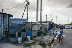 A resident hand washes clothing at a communal tap in the Khayelitsha township, Cape Town, South Africa.