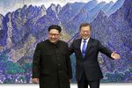 Moon Jae-in, South Korea's president, right, gestures, as he stands with Kim Jong Un, North Korea's leader.