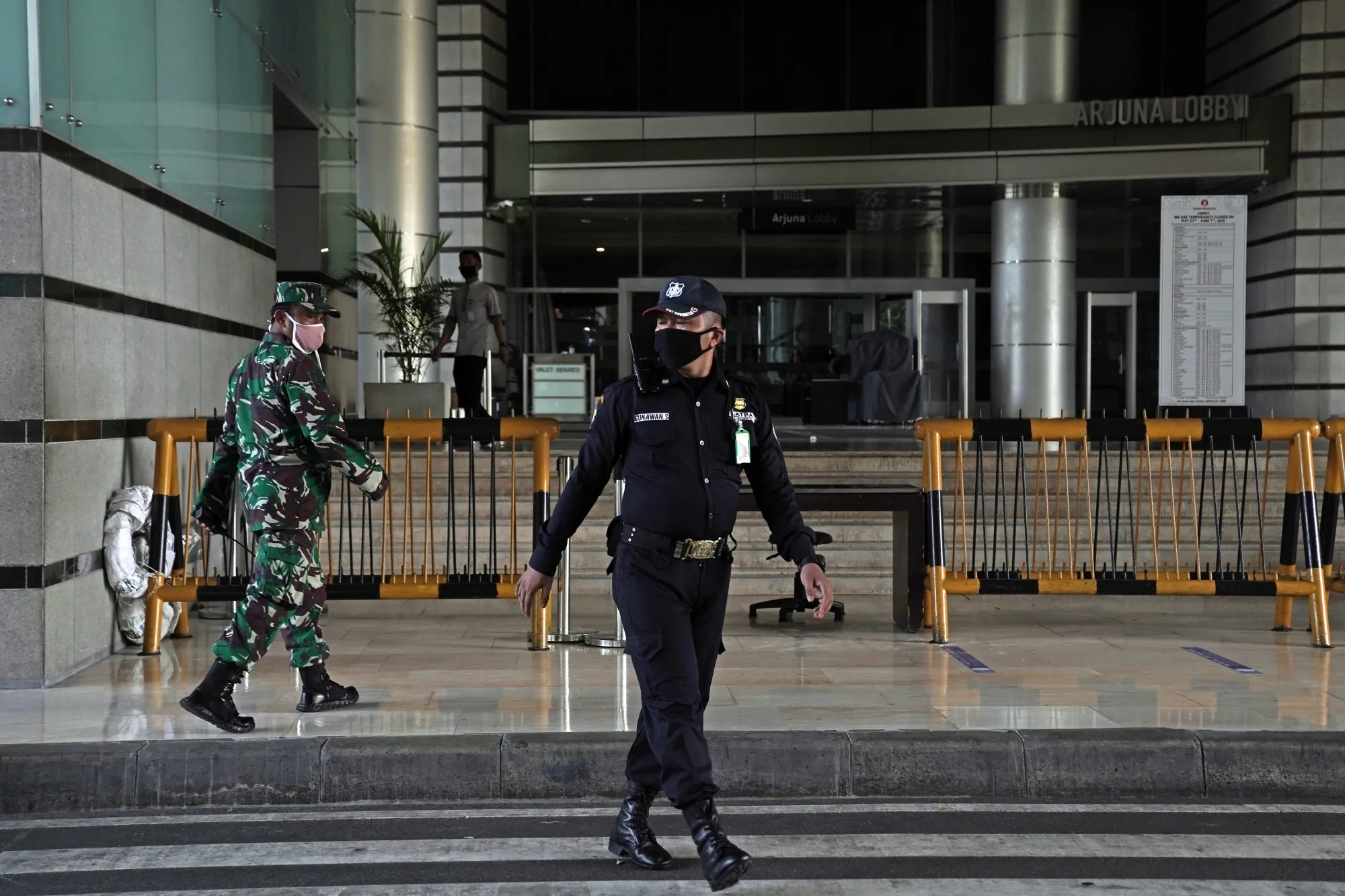 A soldier, left, and a security guard walk outside a shopping mall during a partial lockdown&nbsp;in Jakarta, Indonesia, on May 27, 2020.&nbsp;