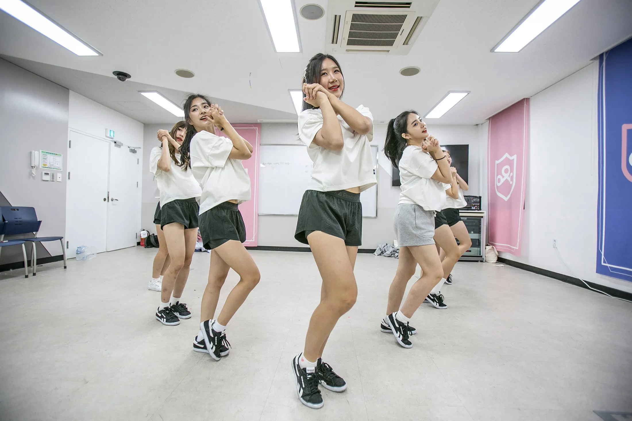 Trainees at “Idol School" practice K-Pop dance moves inside their temporary set.