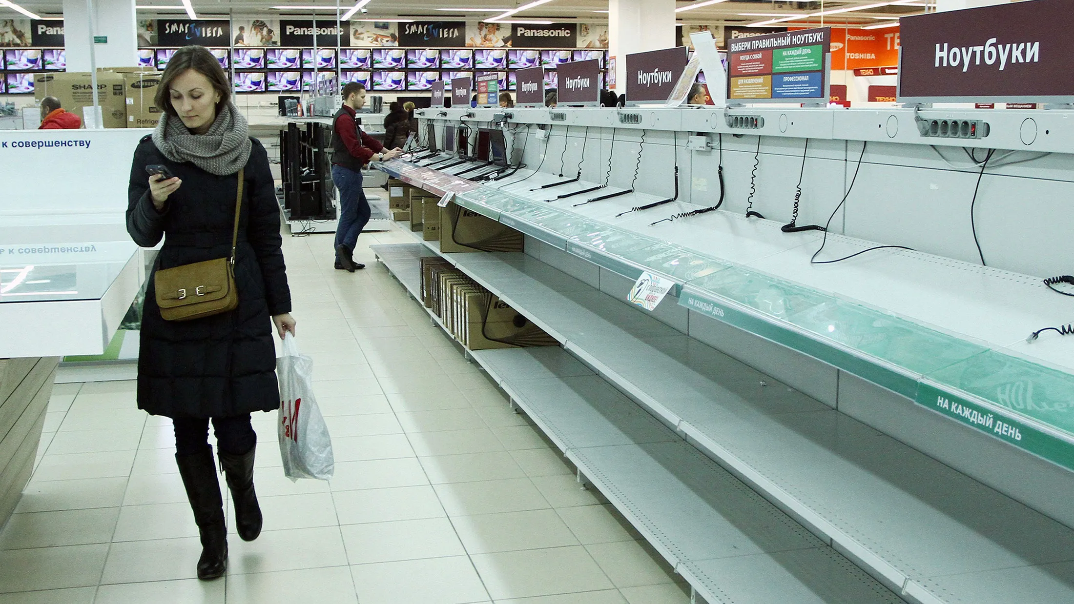 A woman walks past the empty shelves in an electronic shop in Minsk last month.
