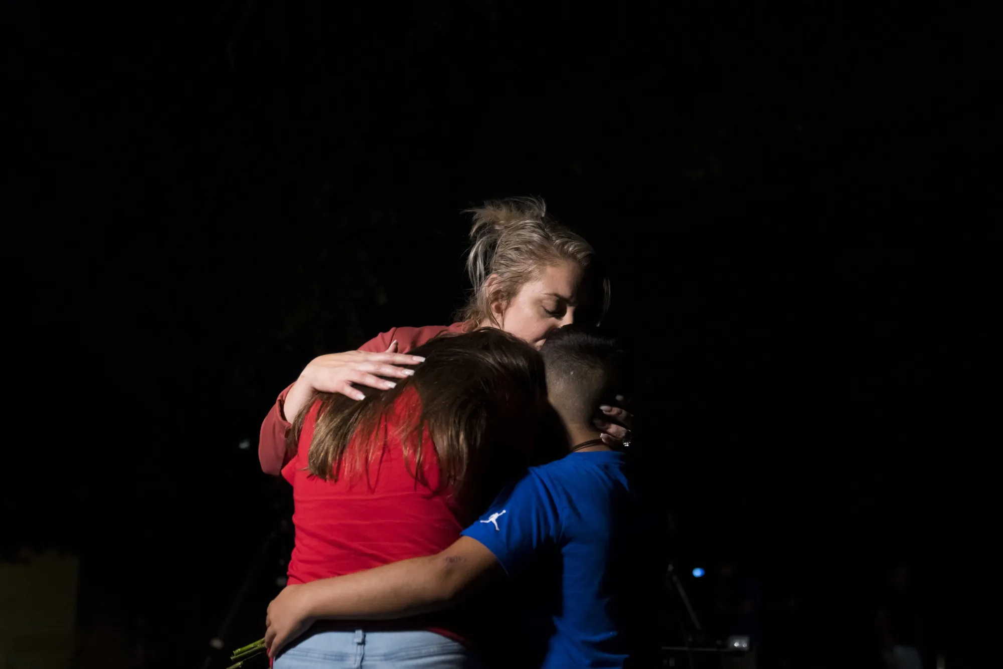 A woman embraces two children outside Willie de Leon Civic Center in Uvalde, Texas, on May 24.