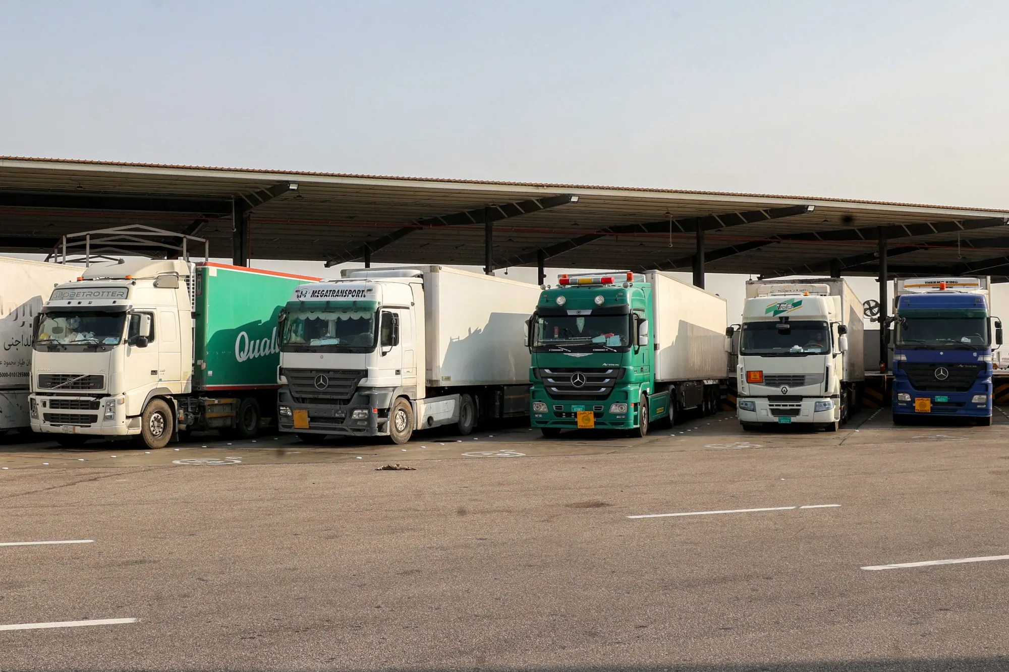 Trucks carrying goods wait to cross&nbsp;the Salwa border-crossing in eastern Saudi Arabia on March 15.