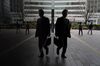 A woman walks outside a train station in Tokyo's business district.