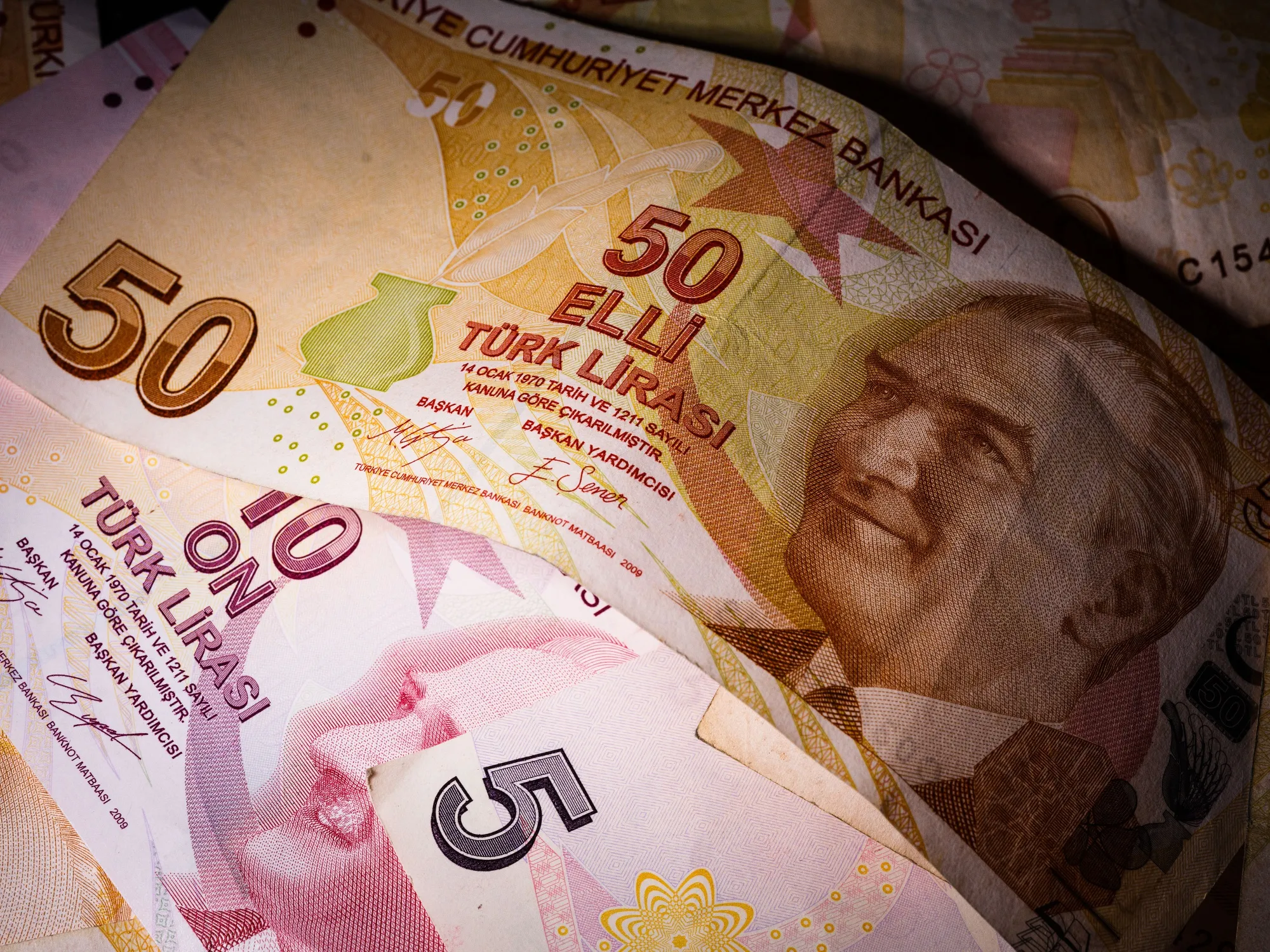 A selection of Turkish Lira banknotes sit on a table in this arranged photograph in London, U.K., on Thursday, Dec. 13, 2018. After being overtaken by Turkey's lira in May, the South African rand’s one-week implied volatility against the dollar is now a hair’s breadth away from regaining the top spot.