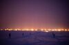 US Marines and Green Beret special forces prepare a mock attack on a NORAD radar station; the sky is all purples and oranges with lights bright as flames in the distance.