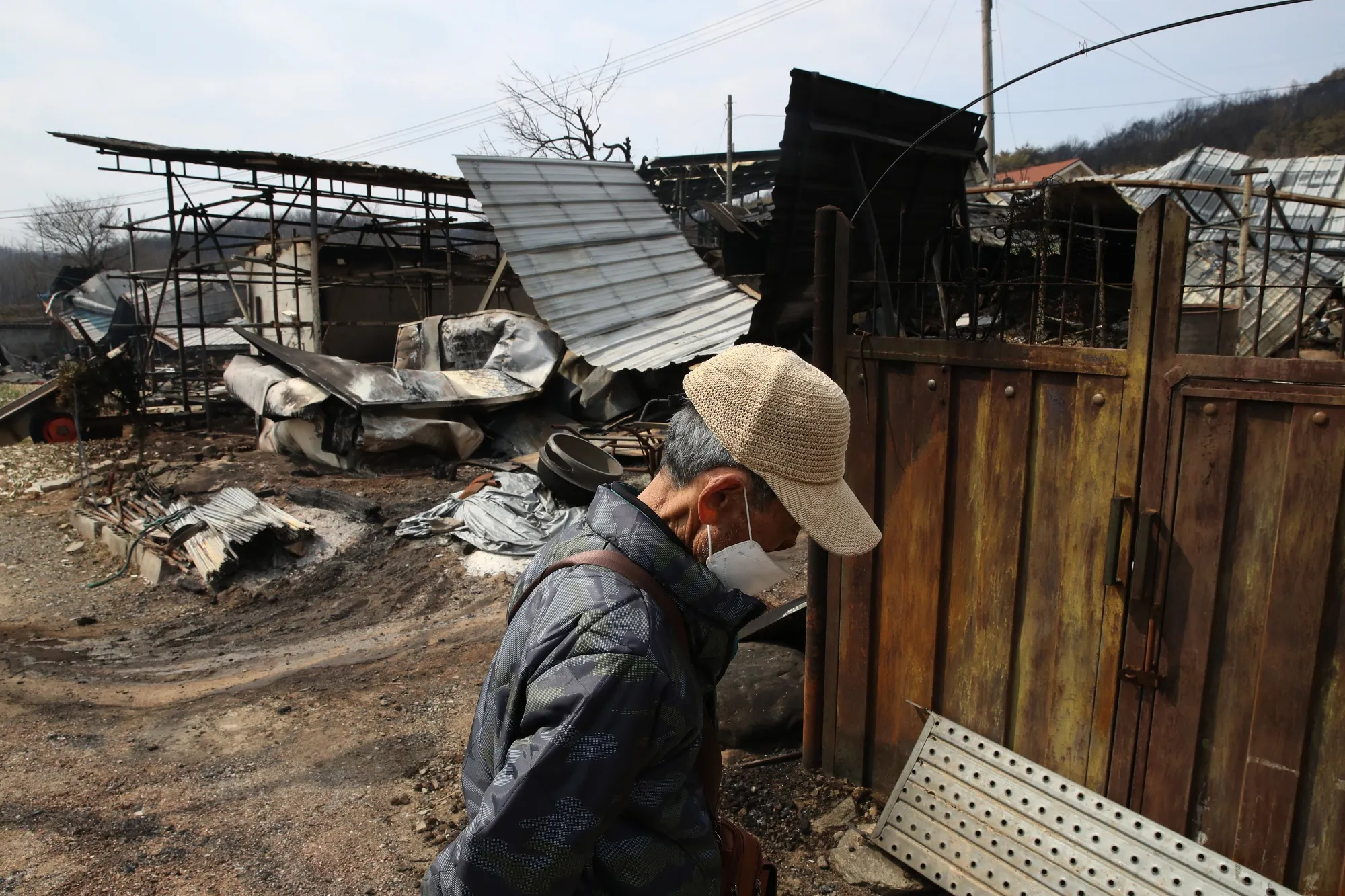 A man inspects his burnt house after a wildfire devastated the area in Andong, South Korea, on March 28.