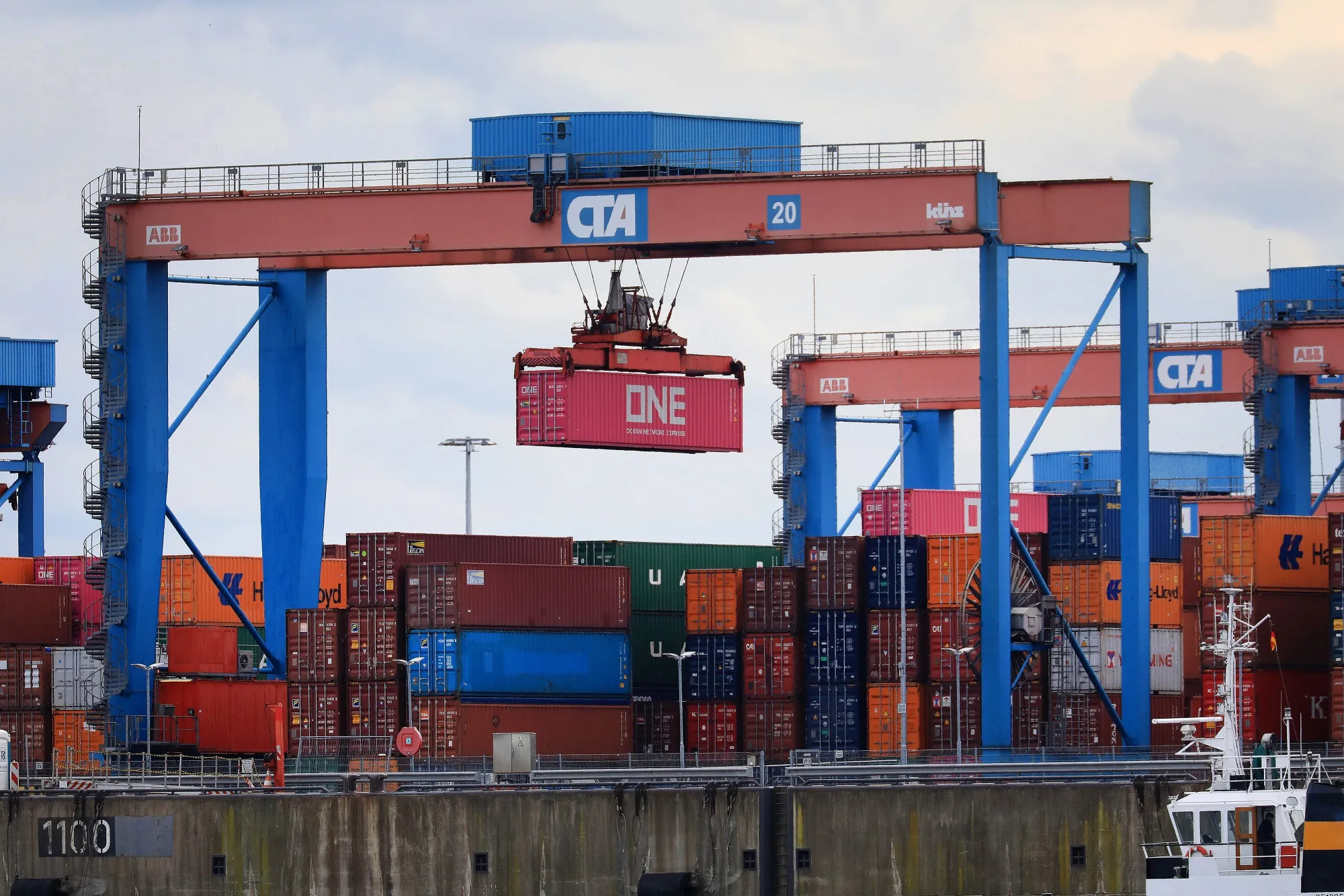 Gantry cranes move shipping containers on the quayside at the Port of Hamburg.