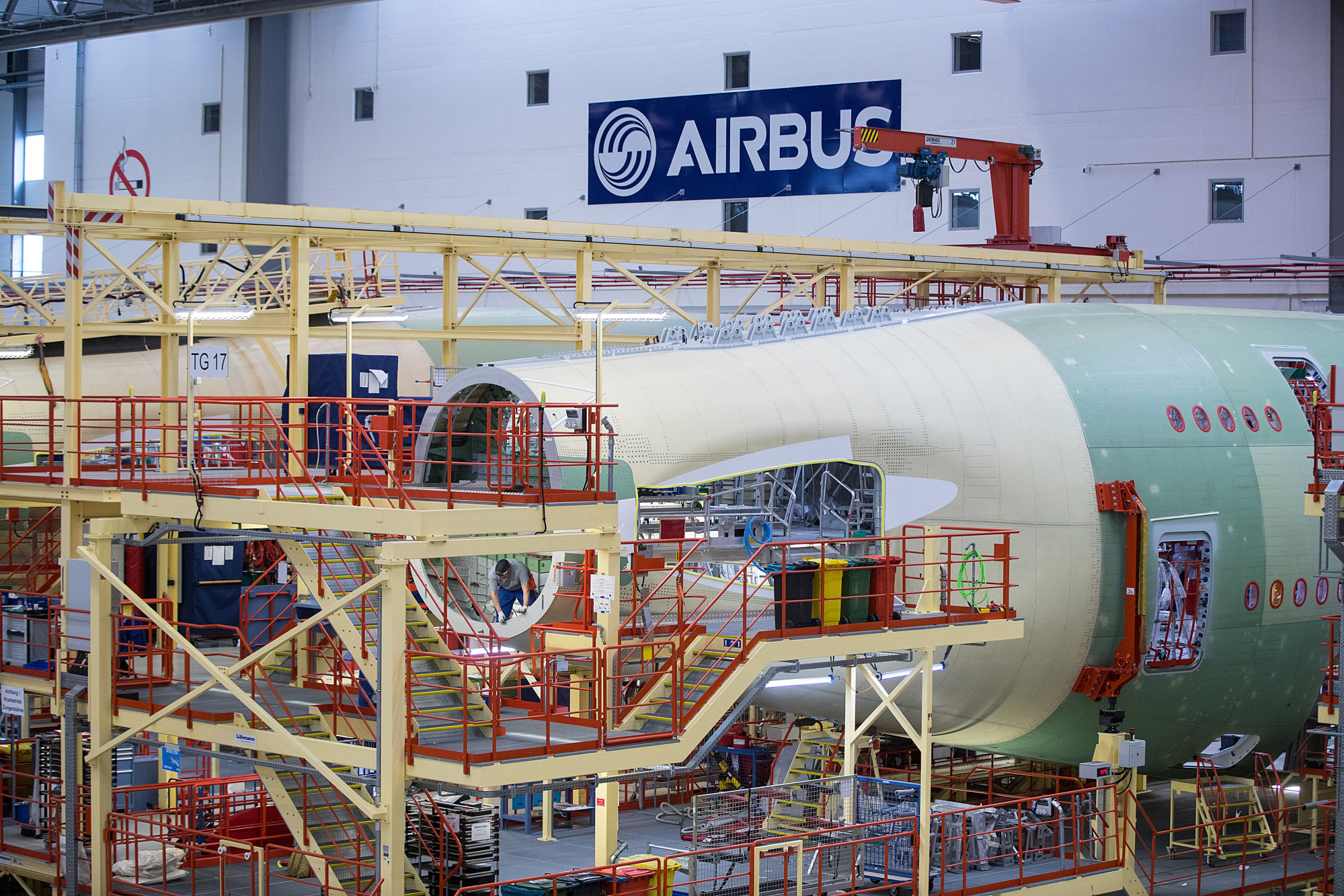 An employee works inside the fuselage tail cone of an Airbus A380 double-deck wide-body jet on the Airbus SE aircraft assembly line in Hamburg, Germany.
