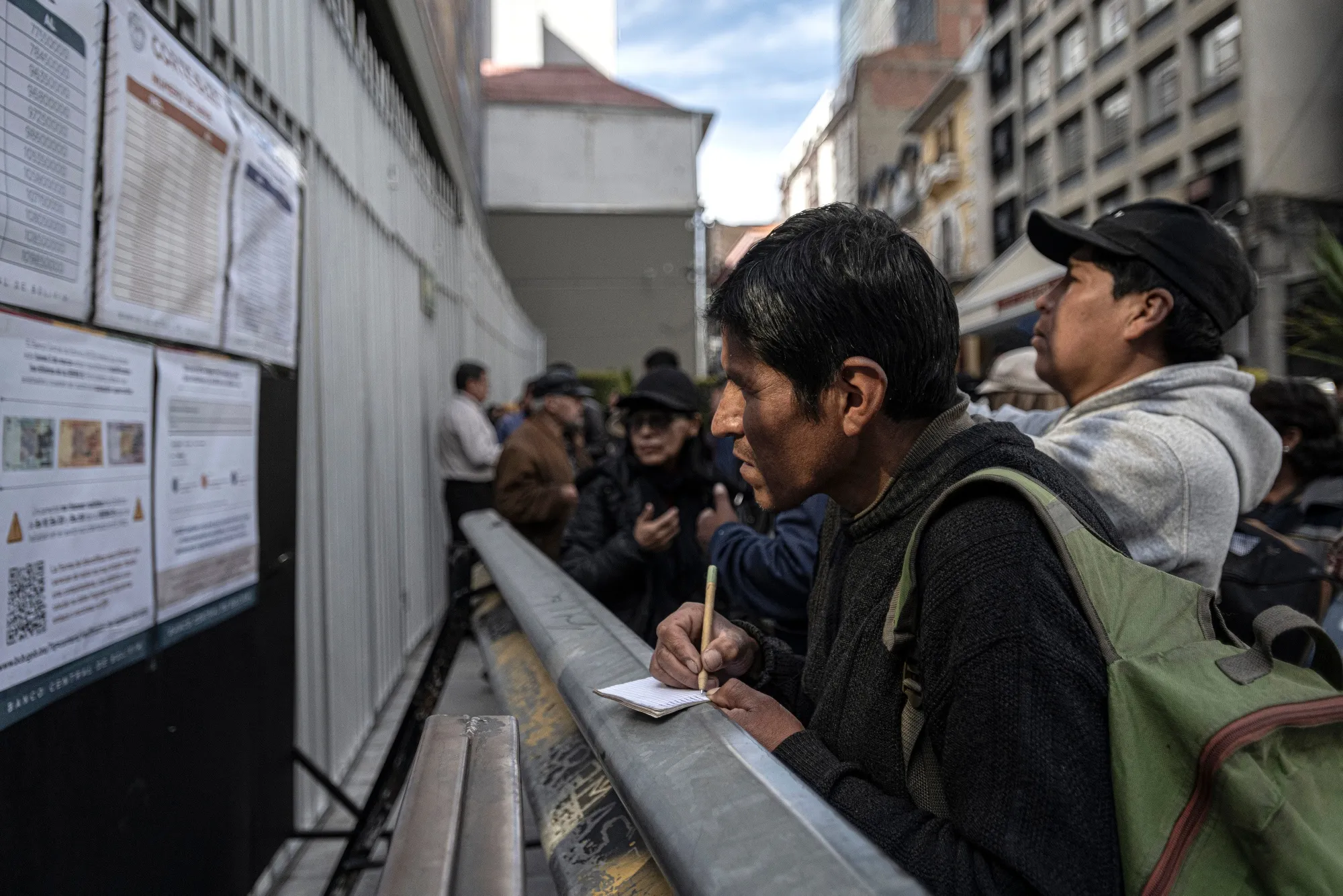 A man takes notes from an official information panel on which banknotes are valid and which are not, outside the Bolivian Central Bank in La Paz on March 3.