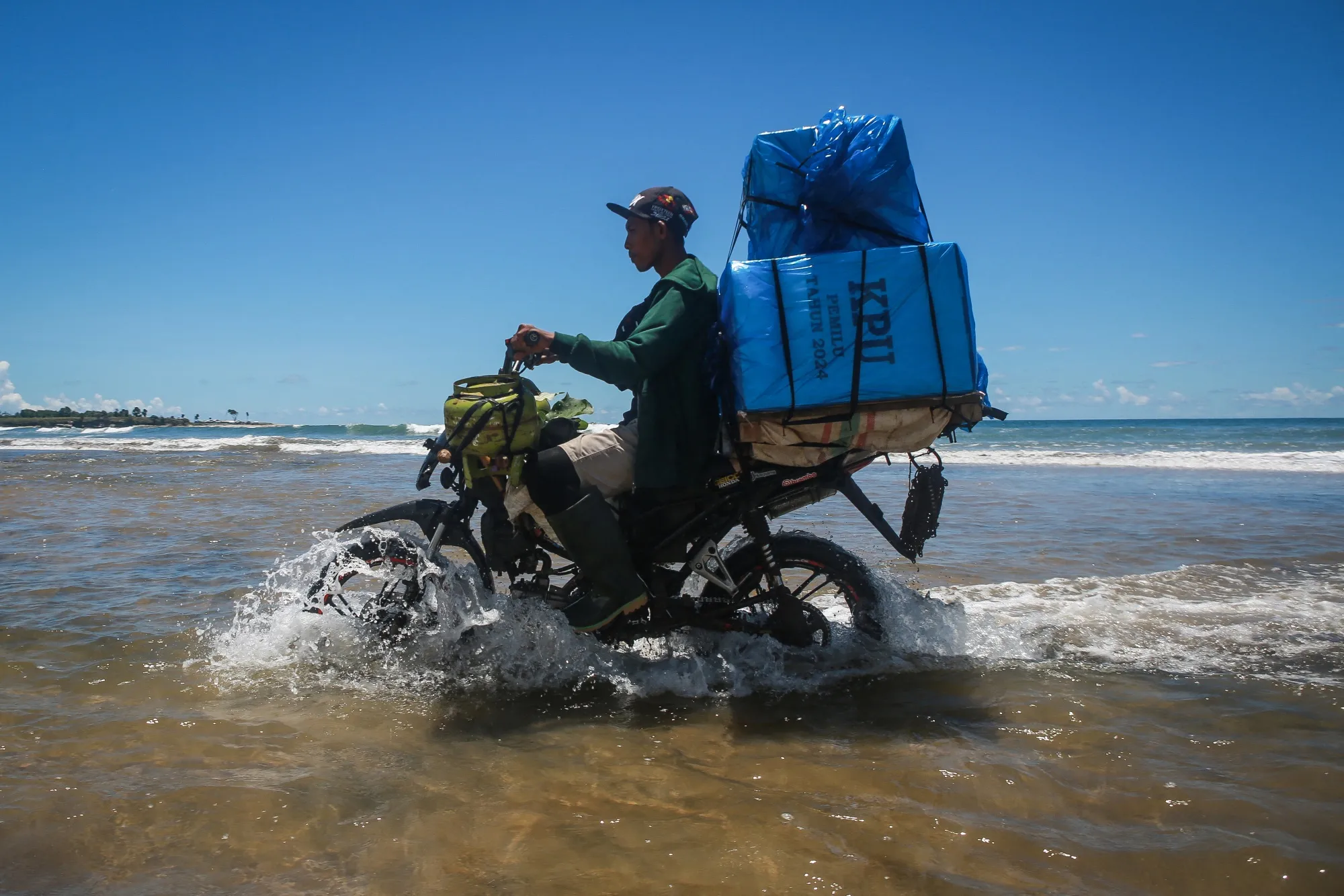 A member of logistics unit of the General Elections Commission delivers election materials by motorbike to remote polling stations&nbsp;in Lampung, Indonesia, on Feb. 11.