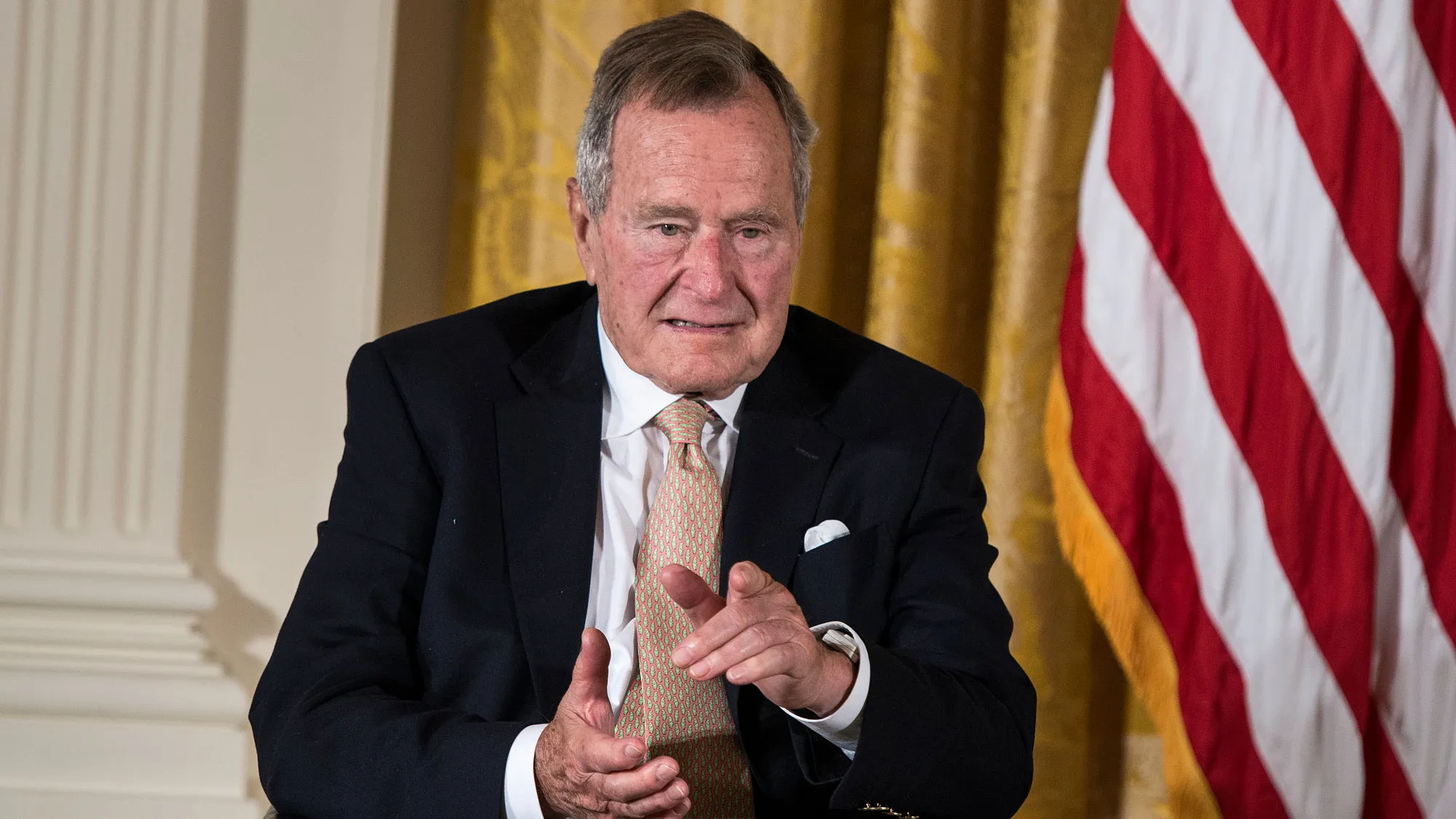 Former US President George H. W. Bush points to his wife Barbara Bush during an event in the East Room of the White House July 15, 2013 in Washington, DC.
