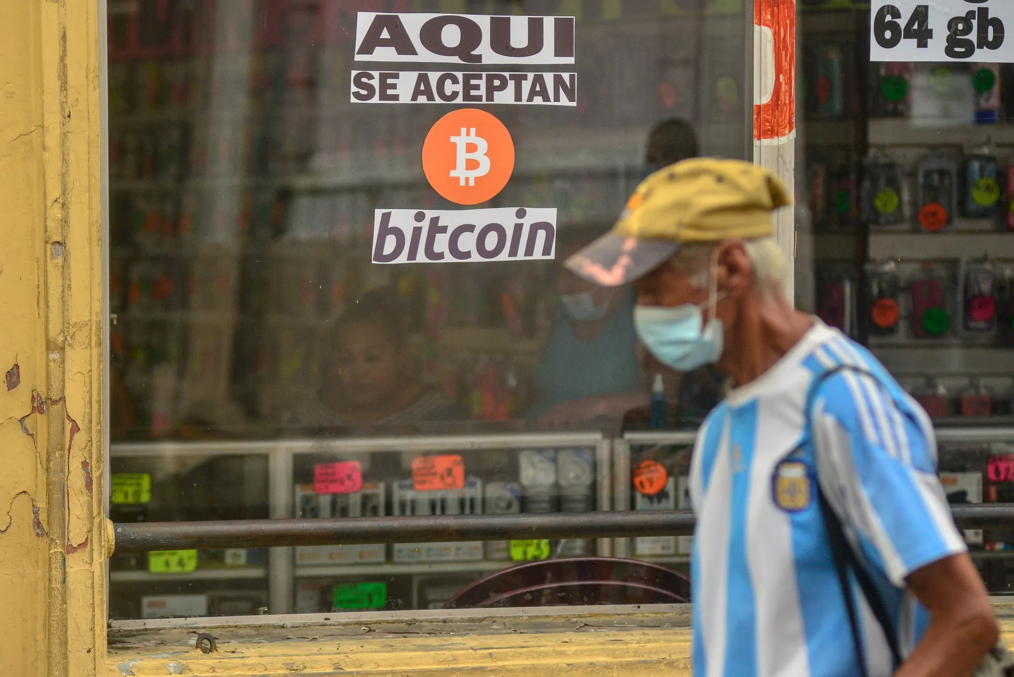 A pedestrian walks by a cellphone accessories shop that accepts Bitcoin in&nbsp;San Salvador, El Salvador.