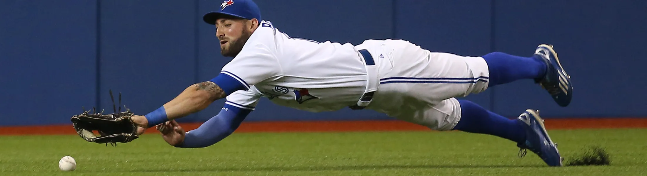 TORONTO, CANADA - AUGUST 11: Kevin Pillar #11 of the Toronto Blue Jays dives but cannot get to an RBI double hit by Danny Valencia #26 of the Oakland Athletics in the first inning during MLB game action on August 11, 2015 at Rogers Centre in Toronto, Ontario, Canada. (Photo by Tom Szczerbowski/Getty Images)
