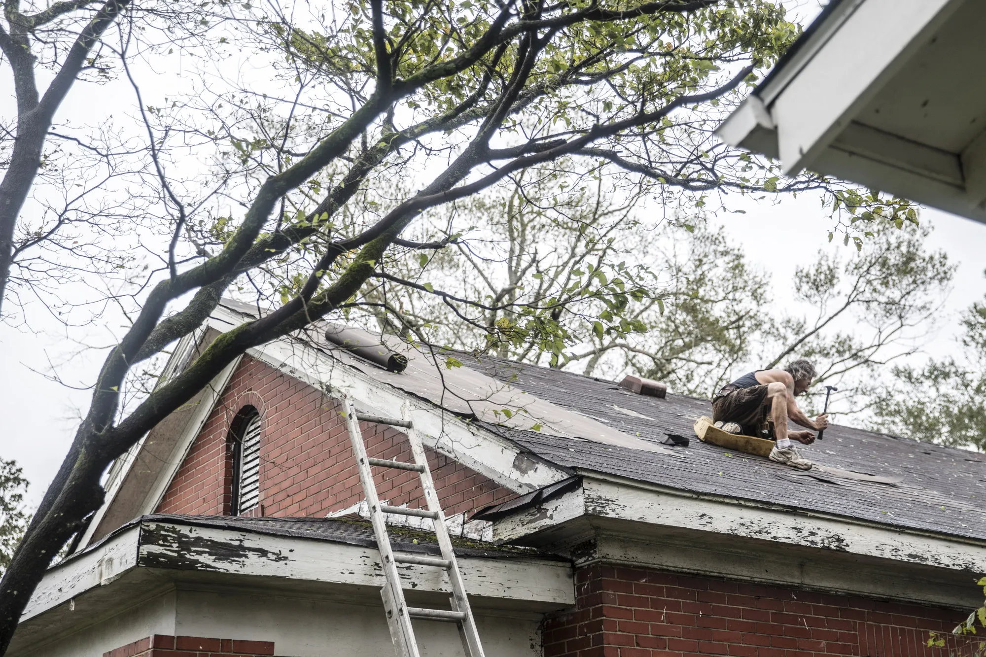 A person works to repair a roof after 2018’s Hurricane Florence hit in Wilmington, North Carolina.