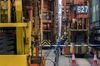 An employee stands next to a wheel of a remote-controlled gantry crane in Container Terminal 9, operated by Hong Kong International Terminal (HIT) - a unit of CK Hutchison Holdings Ltd., at Kwai Tsing Container Terminals in Hong Kong, China, on Tuesday, Jan. 30, 2018. The new system features increases efficiency, enhanced occupational safety, and an improved working environment for crane operators, according to the company.