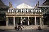 Pedestrians sit outside closed restaurants in Covent Garden in London on March 1.
