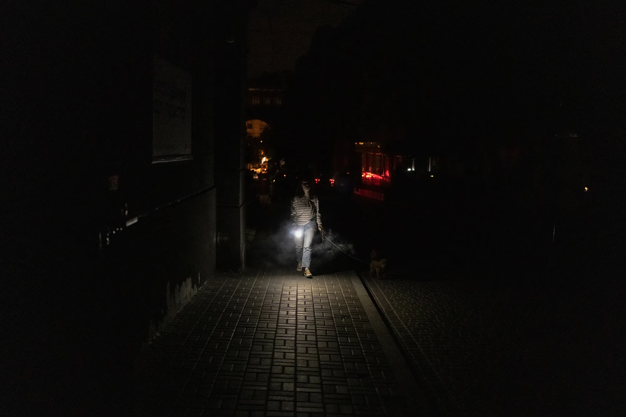 A woman walks down the street during a partial electricity blackout in Kyiv on June 5.
