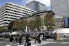 Pedestrians cross a road in front of the Bank of Japan (BOJ) headquarters in Tokyo, Japan, on Wednesday, Oct. 31, 2018. The BOJ stayed the course on monetary stimulus while confirming in updated price forecasts that it won’t meet its inflation target for years to come.