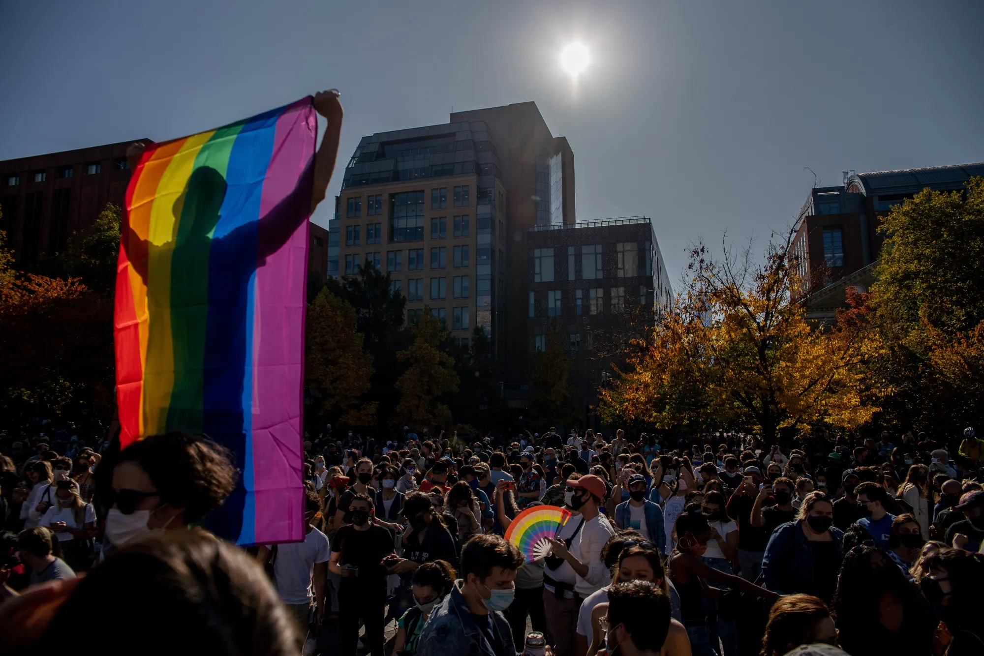 A person holds a rainbow pride flag in New York.