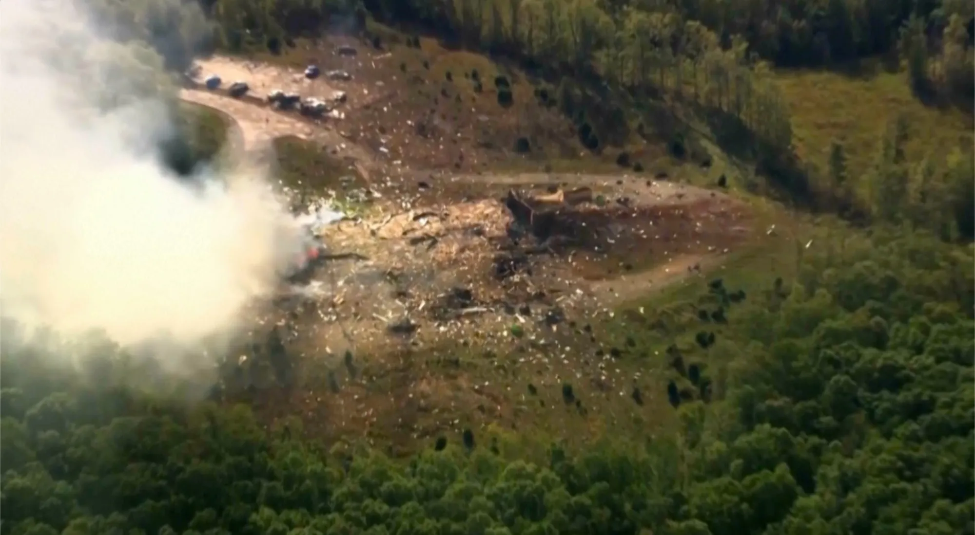 Smoke fills the air as debris covers the ground and vehicles after a powerful blast ripped through a military explosives manufacturing plant in Hickman County, Tenn., on Oct. 10, 2025.