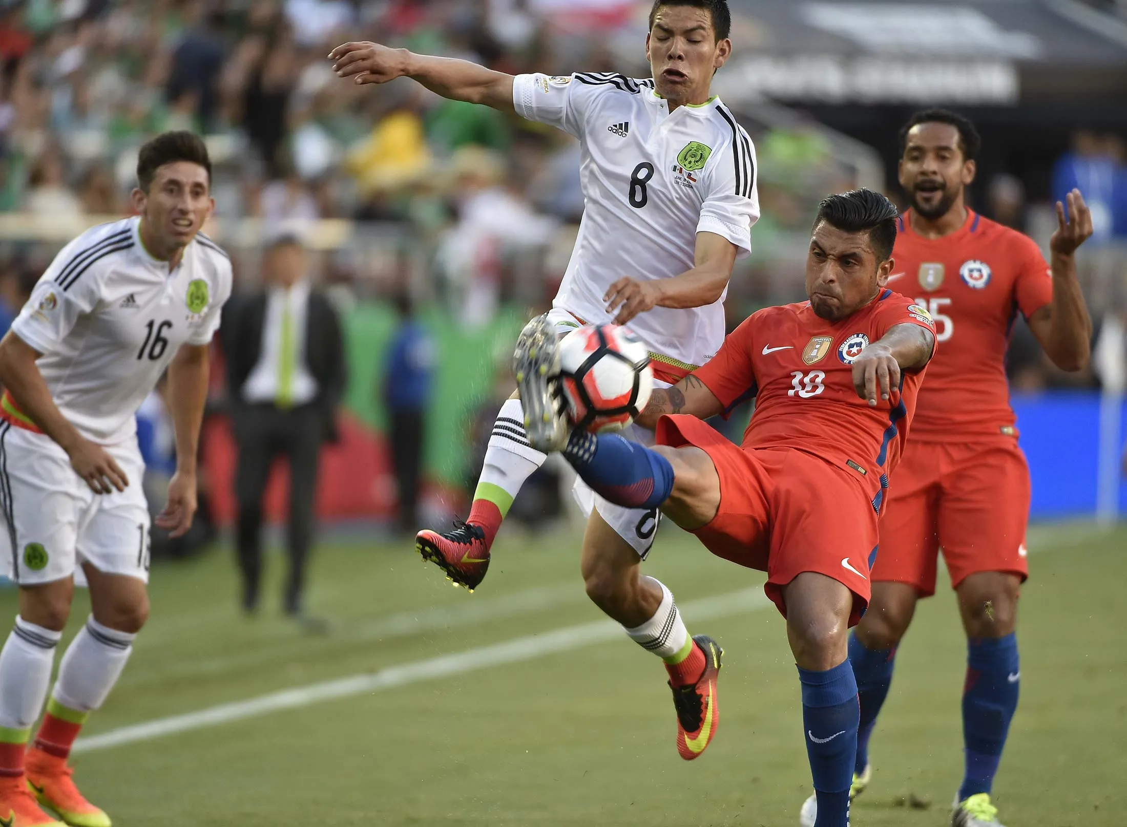 Mexico's Hirving Lozano (C-L) vies for the ball with Chile's Gonzalo Jara (C-R) during the Copa America Centenario quarterfinal football match in Santa Clara, California, United States, on June 18, 2016.
