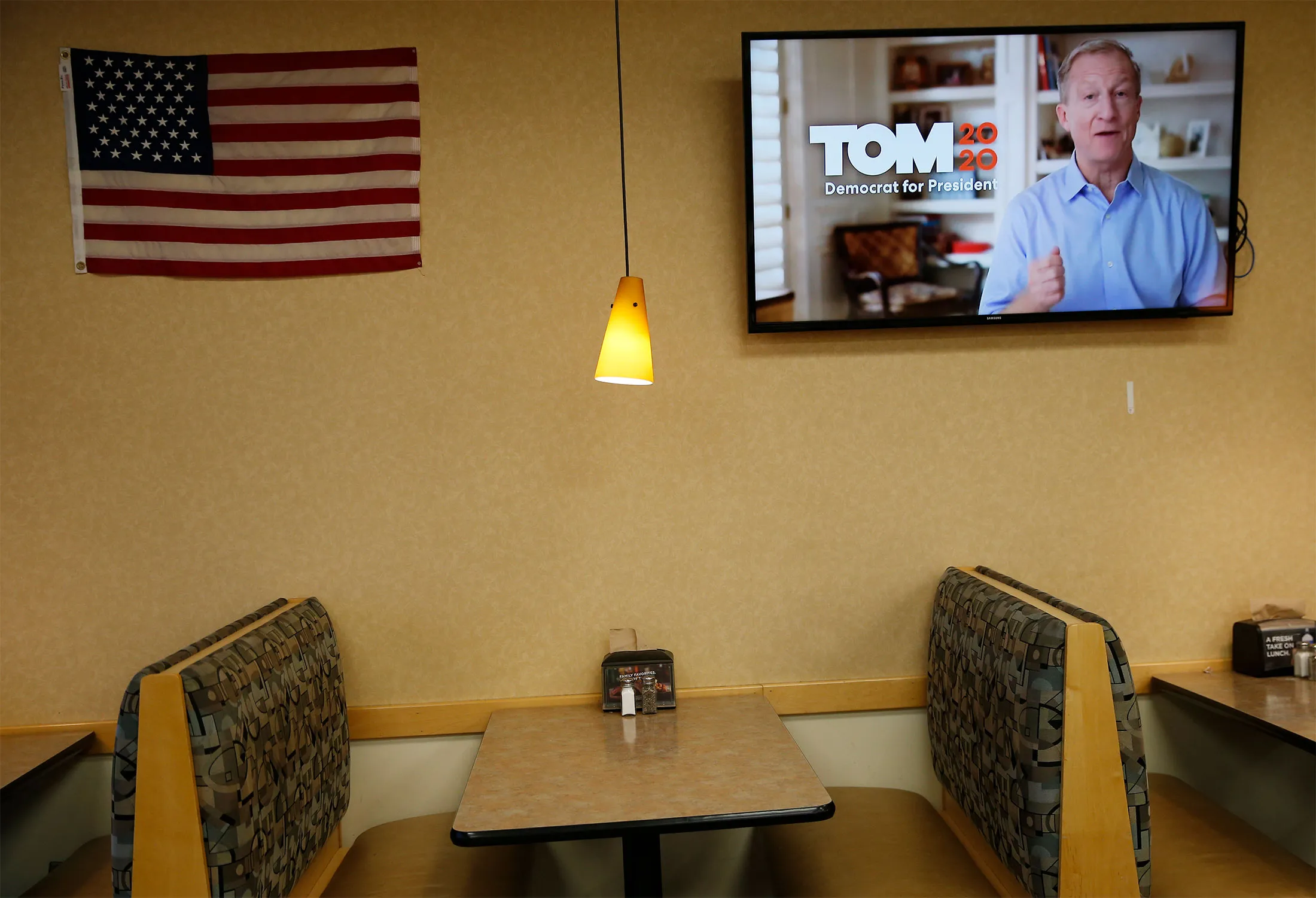 An advertisement for Tom Steyer's presidential campaign plays inside a store in Waverly, Iowa.
