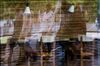 Pedestrians in protective face masks are reflected in a store window in Paris, France, on Wednesday, Aug. 26, 2020.
