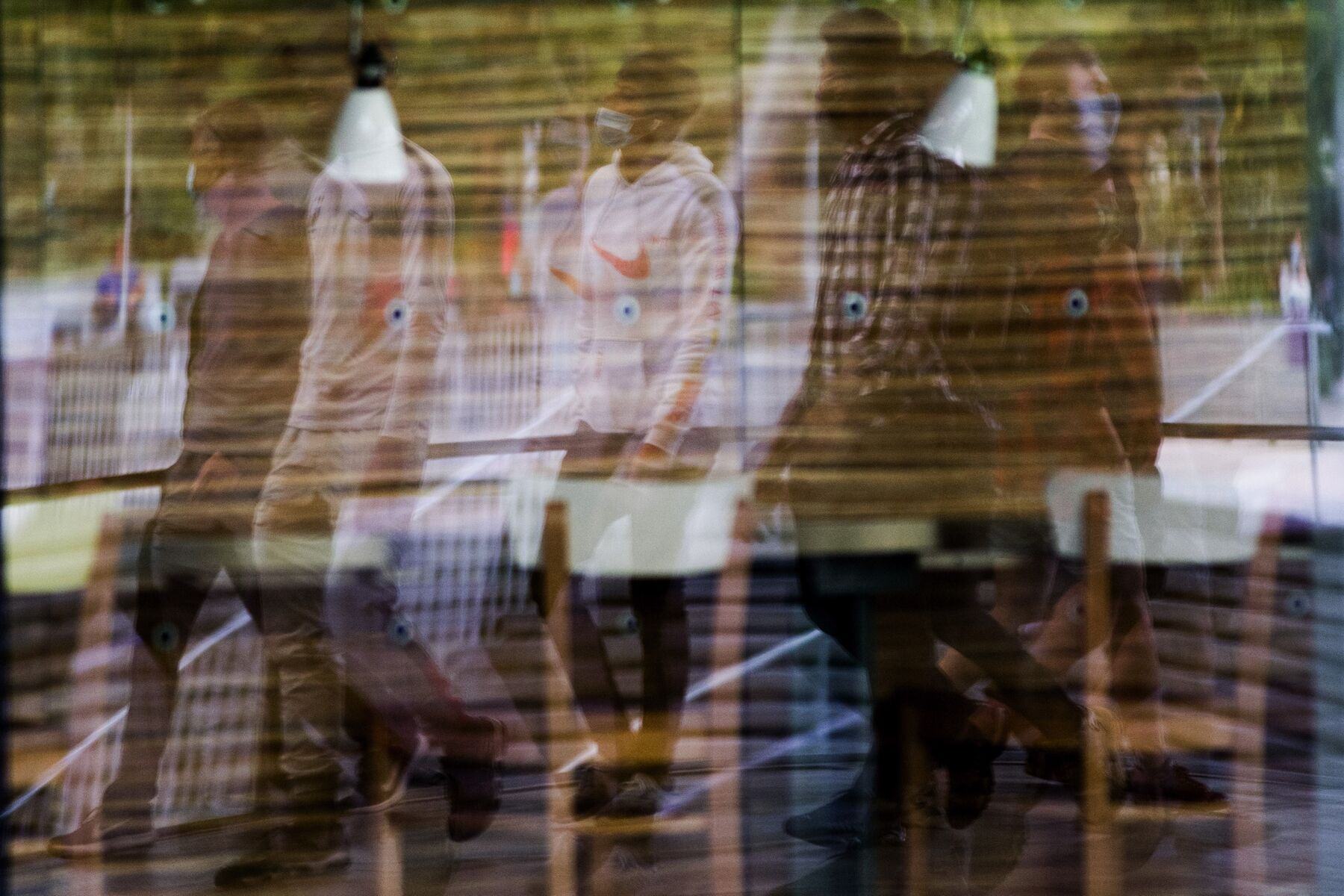 Pedestrians in protective face masks are reflected in a store window in Paris, France, on Wednesday, Aug. 26, 2020. 