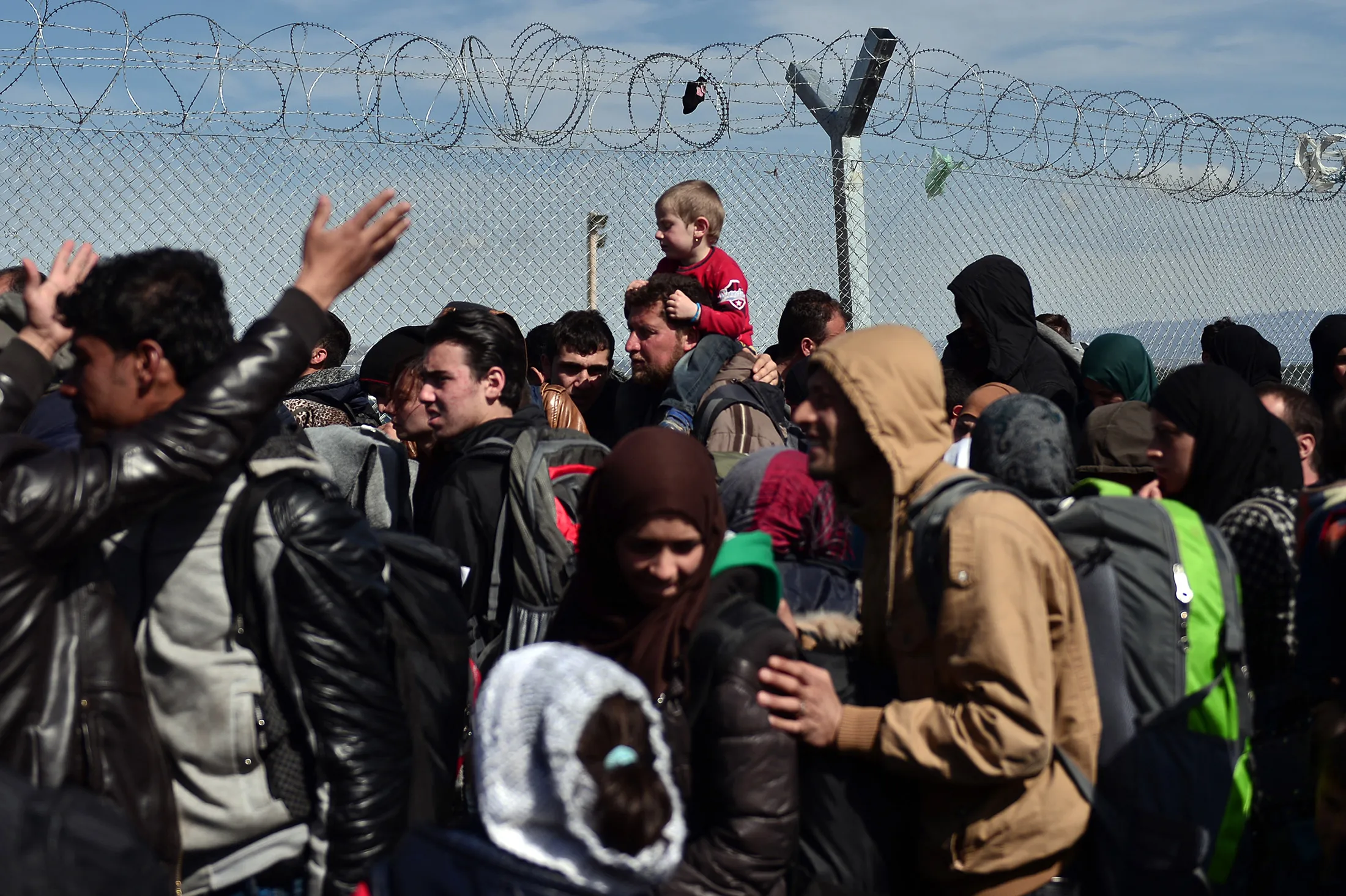 People queue to cross the Greek-Macedonian border near the Greek village of Idomeni, on March 6, 2016.
