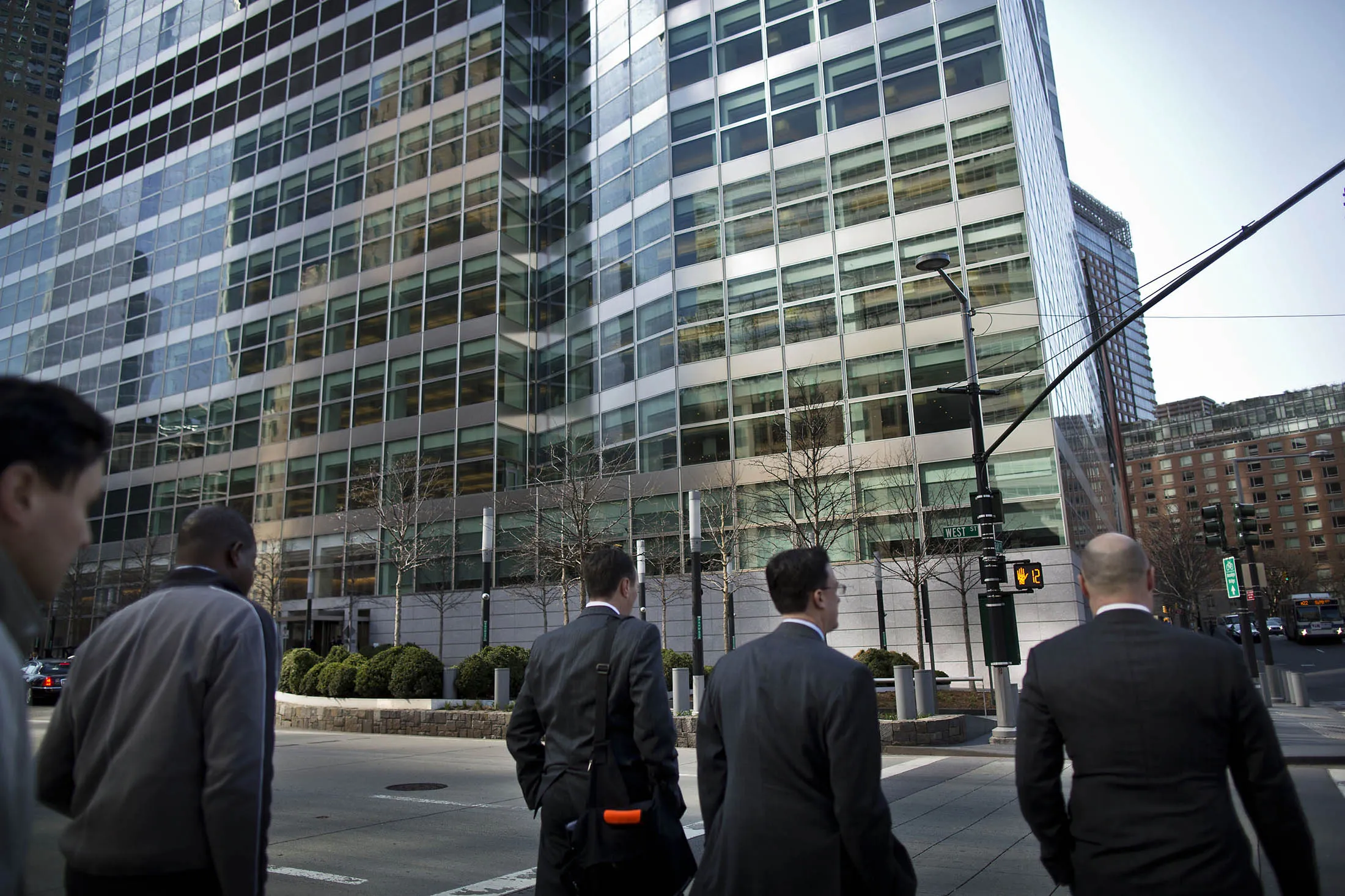 Men cross the street in front of Goldman Sachs's headquarters in New York.
