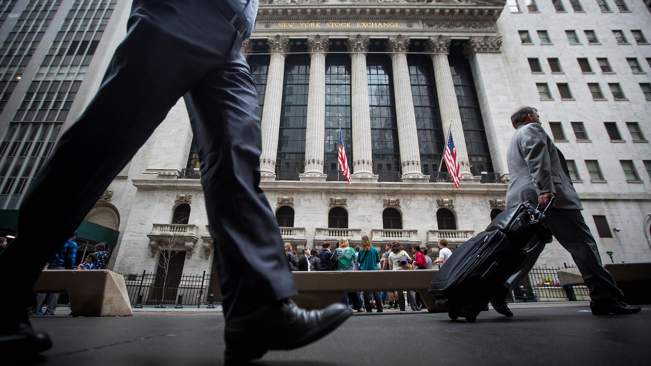 Pedestrians walk past the New York Stock Exchange on April 1, 2016.
