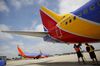 Ground operations employees connect a hose to a Southwest Airlines aircraft on the tarmac at John Wayne Airport in Santa Ana, California.
