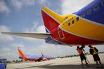 Ground operations employees connect a hose to a Southwest Airlines aircraft on the tarmac at John Wayne Airport in Santa Ana, California.