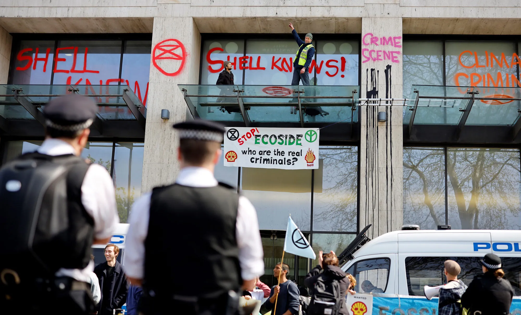 Activists stand over the entrance to the Shell Centre in London on April 15.