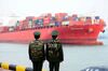 TOPSHOT - Chinese police officers watch a cargo ship at a port in Qingdao in China's eastern Shandong province on March 8, 2018.China's trade surplus with the United States narrowed for a second month in a row in February, dropping to 21 billion USD, official data showed on March 8, amid rising trade tensions with the Trump administration. / AFP PHOTO / - / China OUT (Photo credit should read -/AFP/Getty Images)