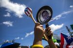 A demonstrator bangs on a pan displaying an image of Ricardo Rossello during a protest in San Juan, on July 22.