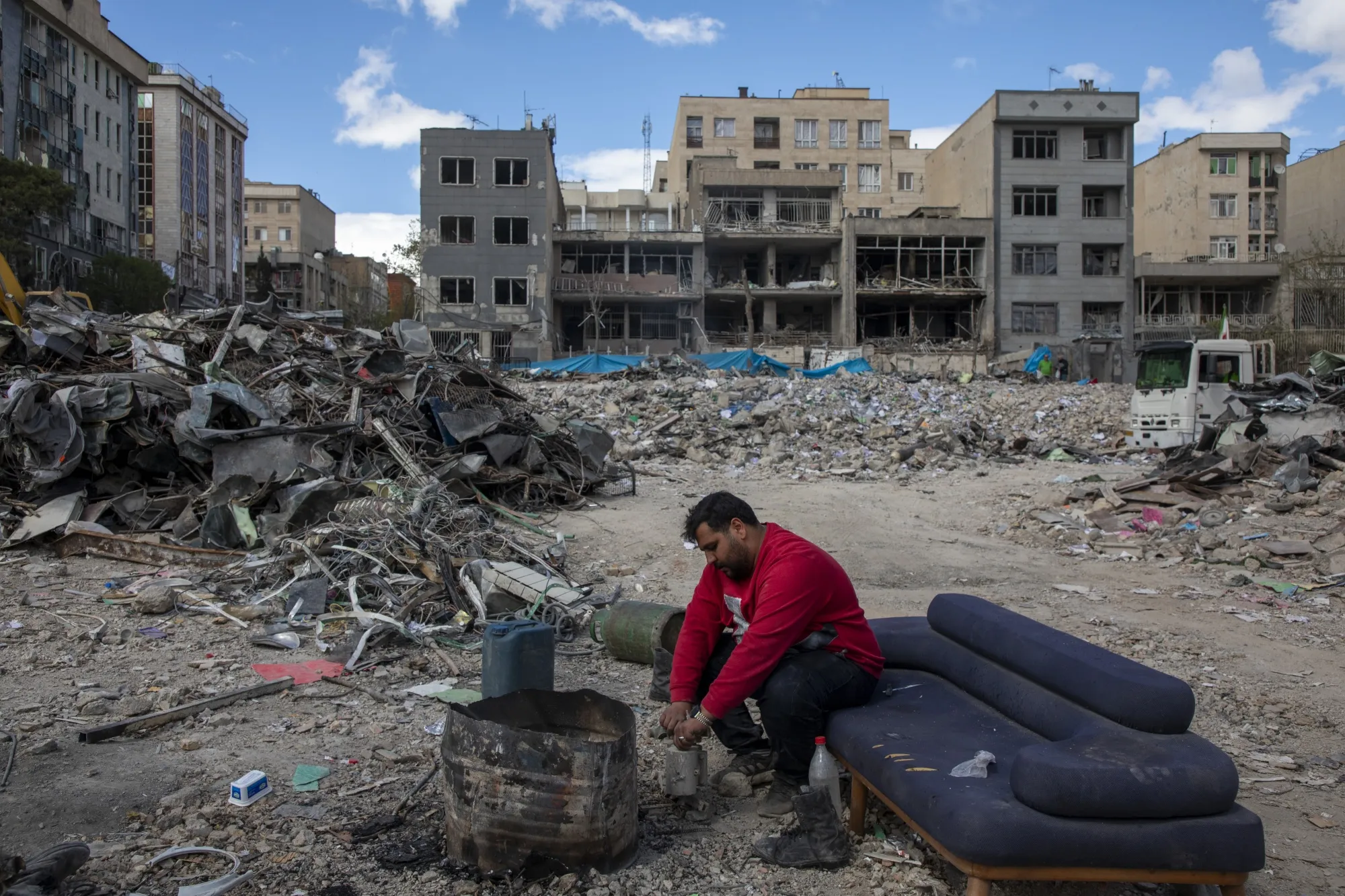 A man sits among buildings destroyed in an airstrike in Tehran on April 6.&nbsp;