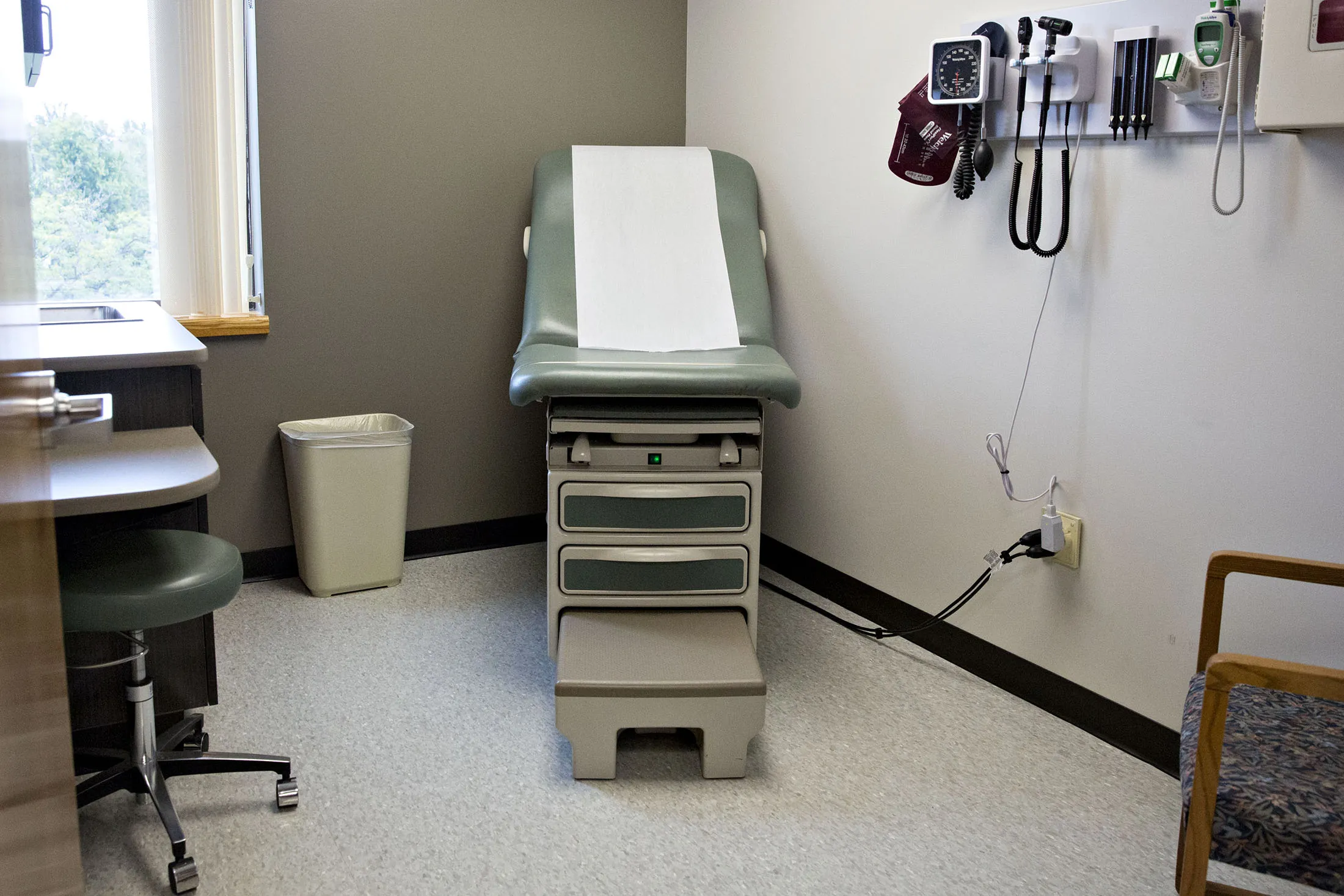 An exam bed sits in a room at a hospital