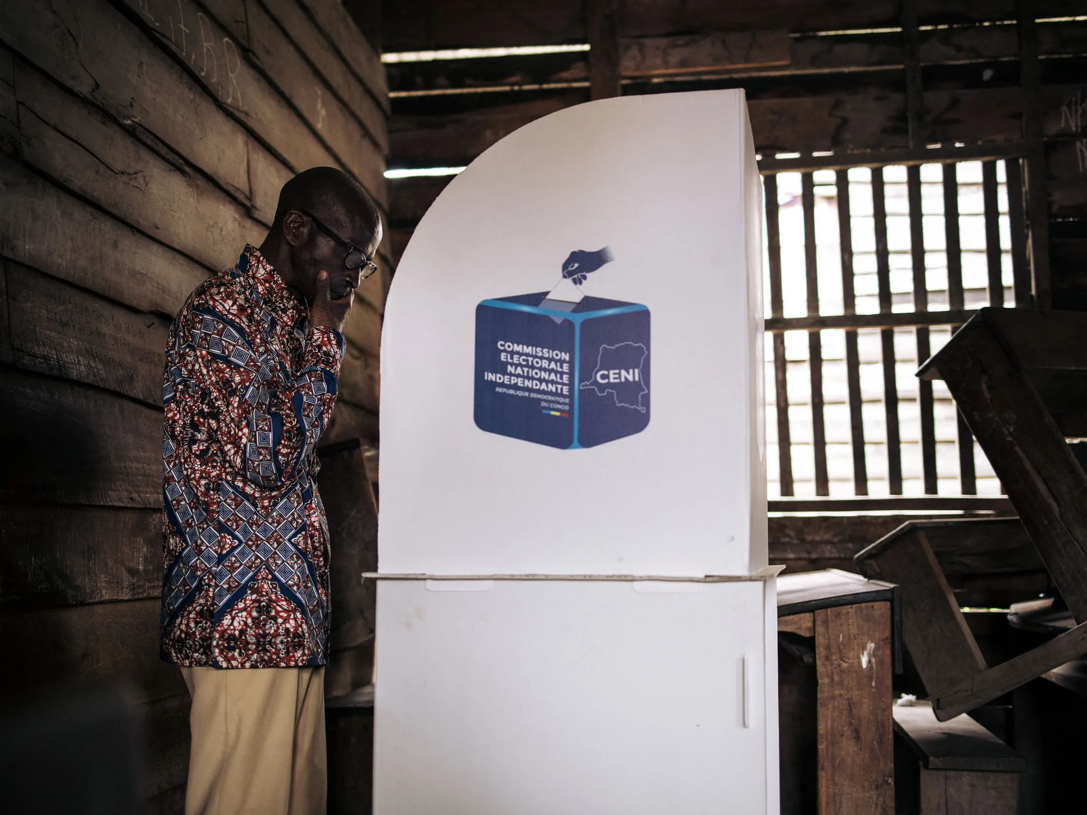 A voter marks his ballot in a voting booth in Goma on Dec. 21.