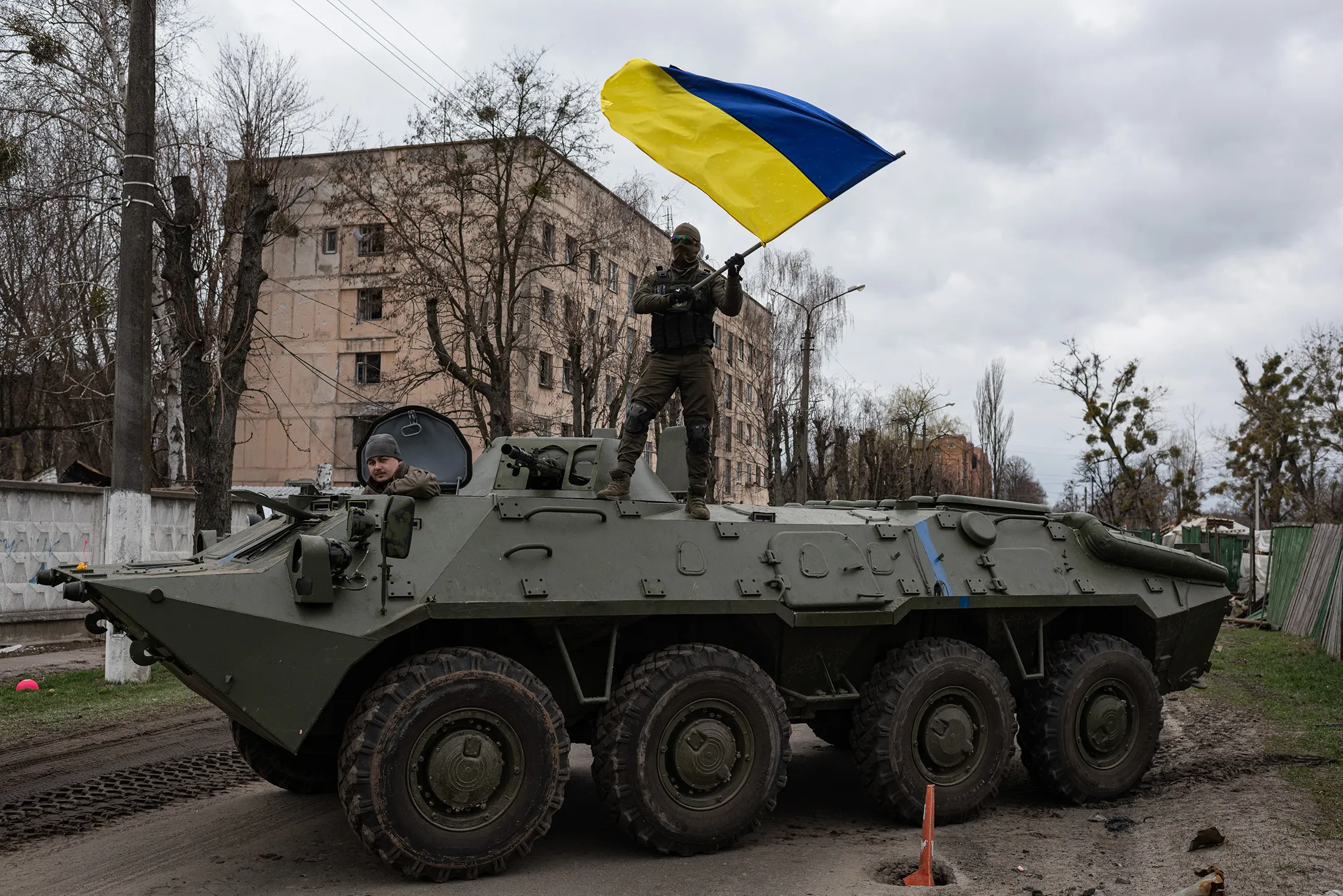 A soldier waves the Ukrainian national flag while standing on top of an armored personnel carrier in Hostomel&nbsp;on April 8.