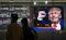 Pedestrians walk past a news broadcast of the U.S. presidential election result in Tokyo on Nov. 9. Photographer: Tomohiro Ohsumi/Bloomberg