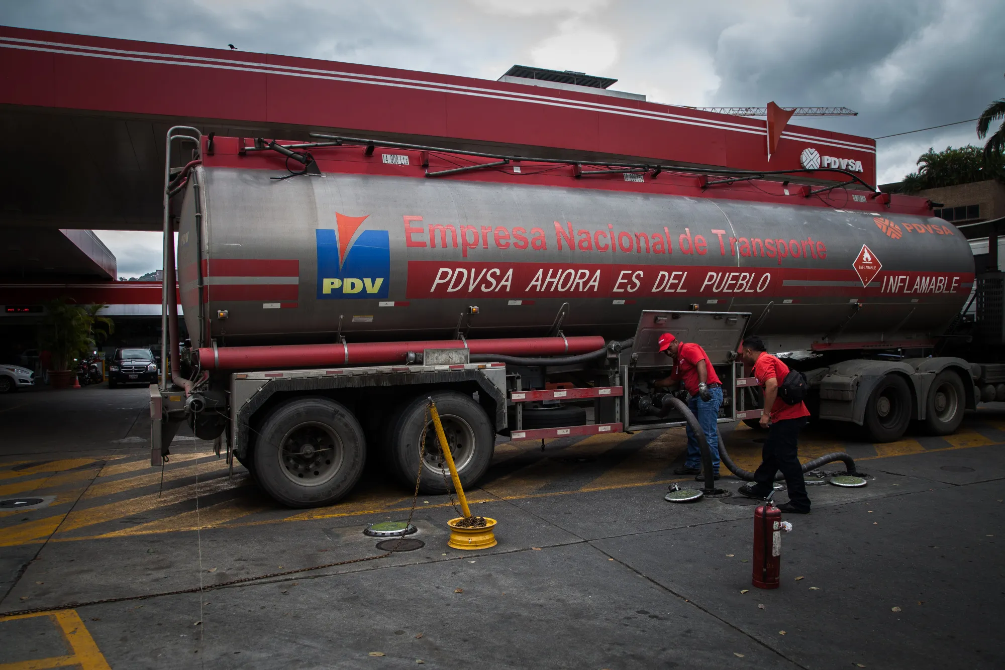 Employees work at a Petroleos de Venezuela SA (PDVSA) gas station in Caracas, Venezuela.