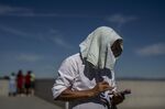 A man covers his head from the sun on a hot day in Madrid, Spain, Friday, June 10, 2022. Temperatures are rising with predictions that it will reach over 40 degrees Celsius (104 degrees Fahrenheit) by the weekend in some parts of Spain. (AP Photo/Manu Fernandez)