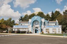 A parking lot and building with a “Republic of Khalistan” banner displayed on one side of the front of the building.