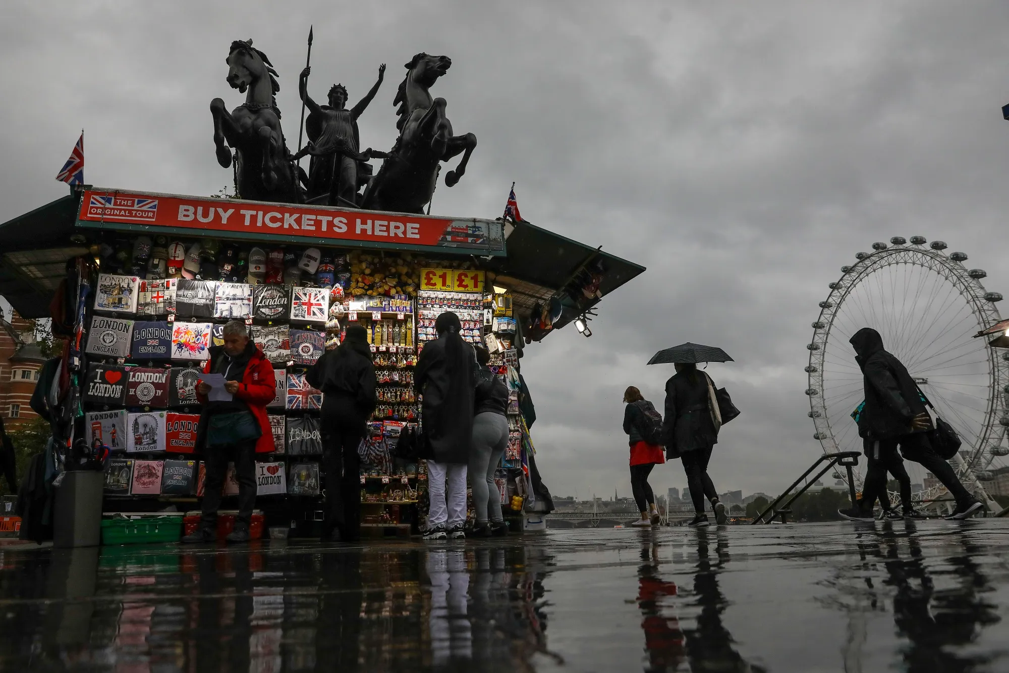 Pedestrians walk past a tourist souvenir stall on Westminster Bridge in London.&nbsp;