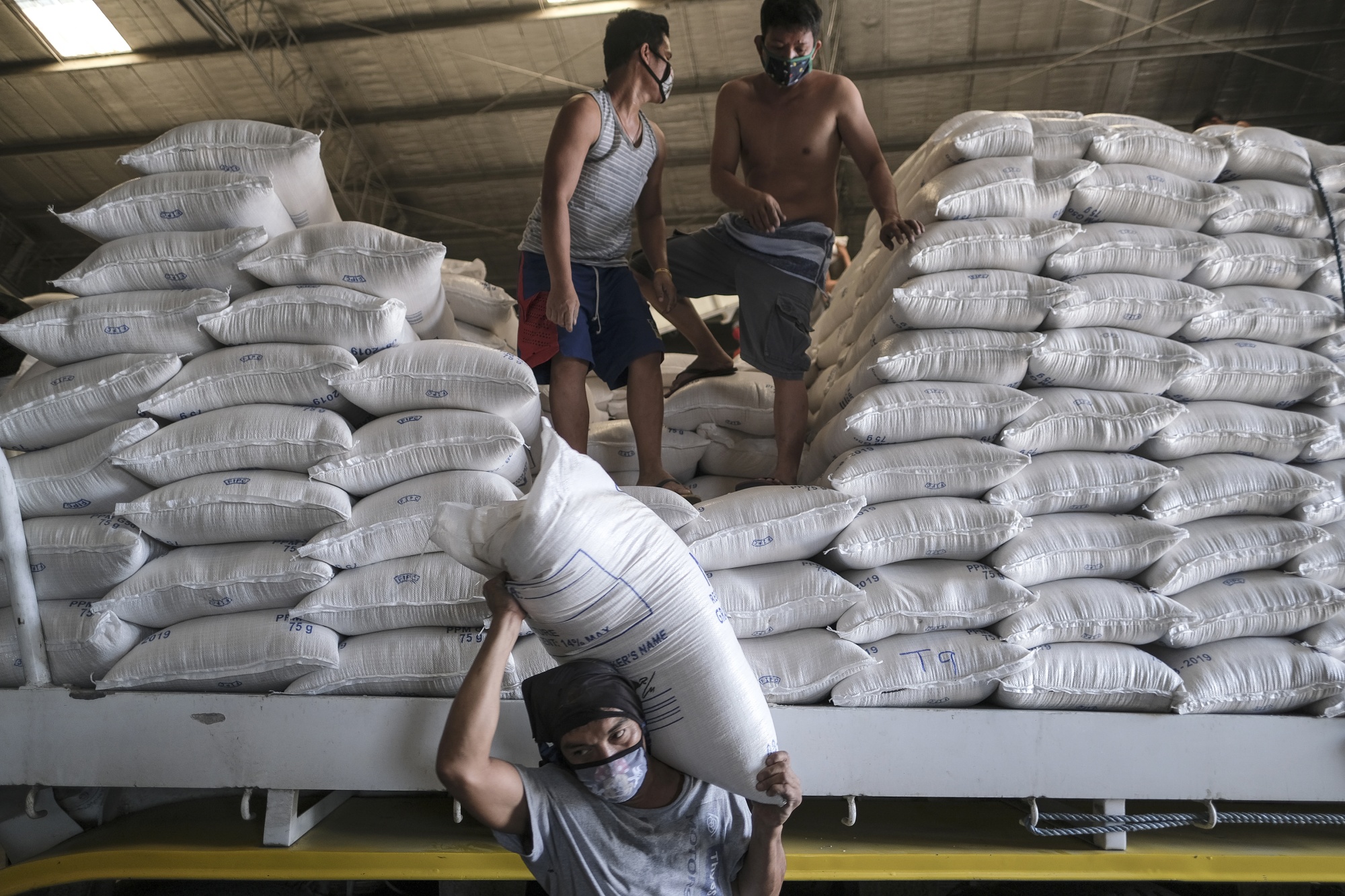 Thai workers prepare rice sacks to be sold at the Department of