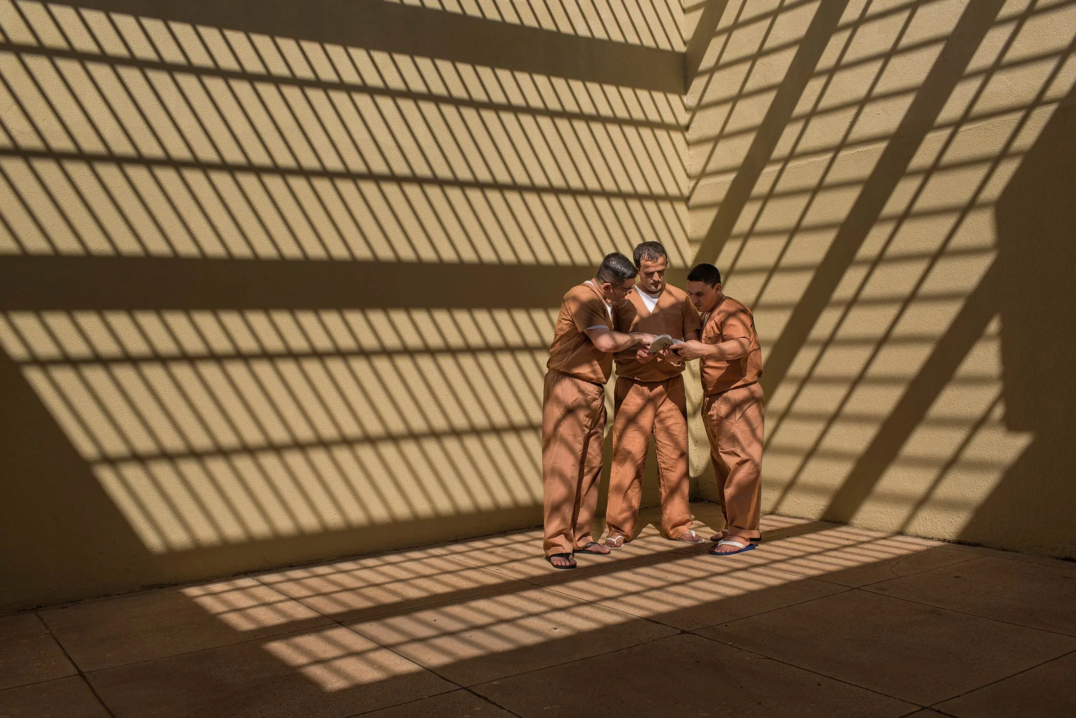A trio of detainees read the Bible in the courtyard of the Compact Penitentiary Osvaldo Cruz in the State of Sao Paulo, Brazil, on Tuesday, July 31, 2018. All are evangelicals.